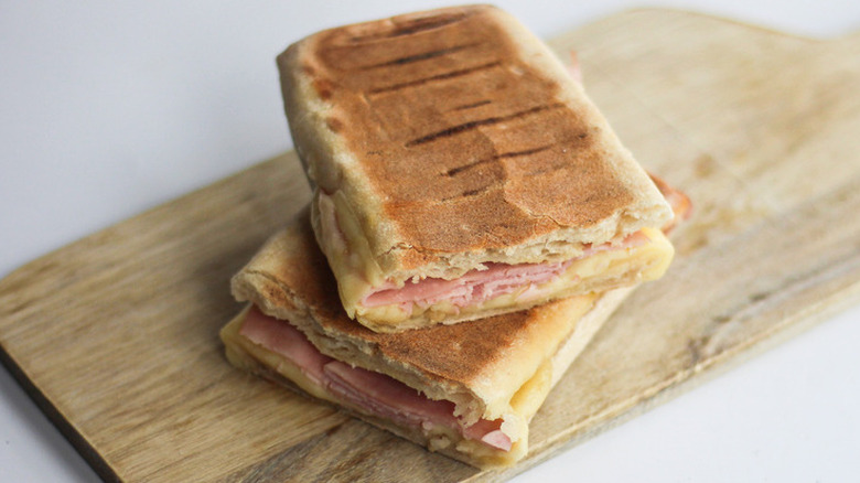 Flat halves of a ham cheese panini sandwich.