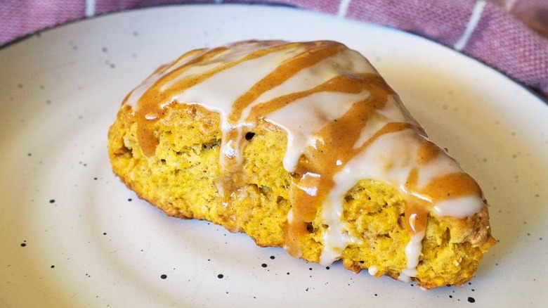 Orangey-brown scone with white and brown glaze.