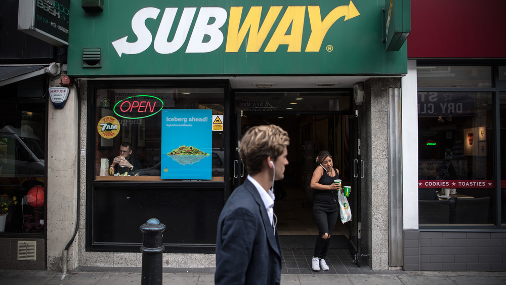 Subway storefront with man walking in front of it