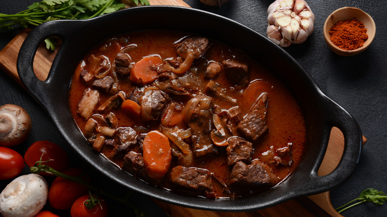 An oval-shaped dutch oven filled with beef stew