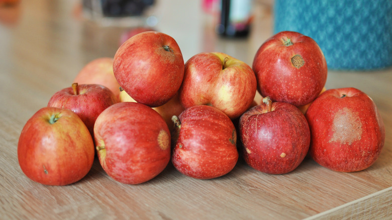 Blemished apples on a surface