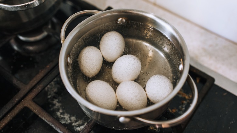 Eggs boiling in pot of water