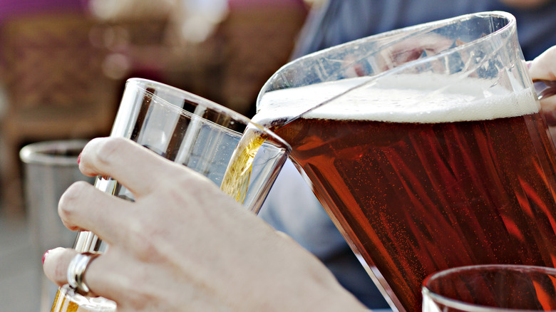 Pouring beer from pitcher into glass