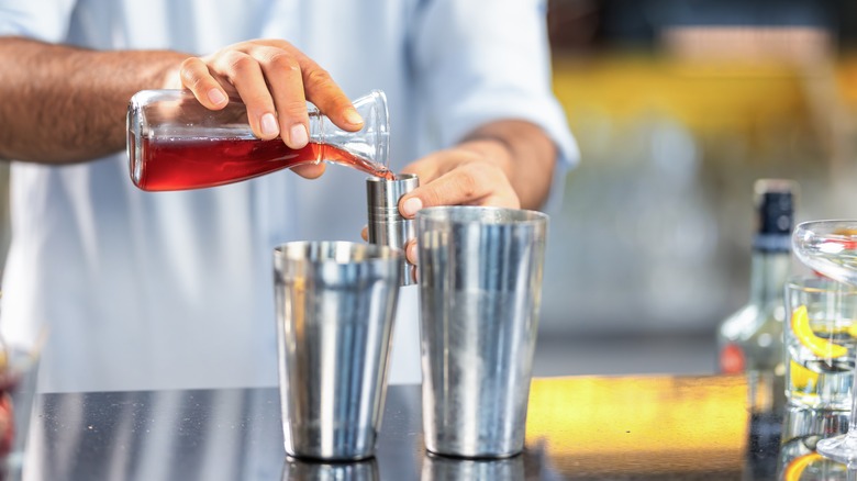 bartender measuring cocktail ingredient