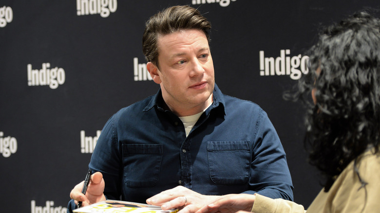 Jamie Oliver signing book for fan