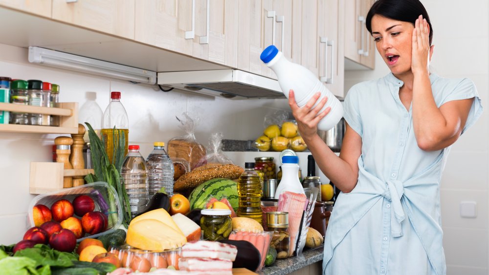 woman looking at a bottle of milk