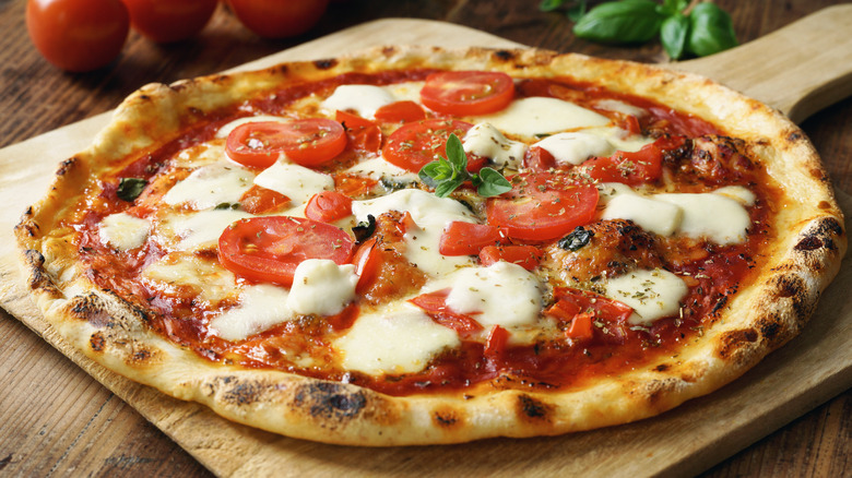 A pizza on a wooden holder