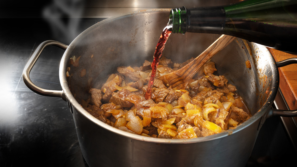 Wine added to goulash in pot