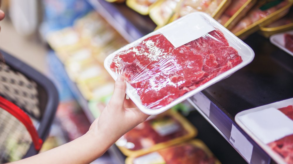 Steak wrapped in plastic for sale on grocery store shelf