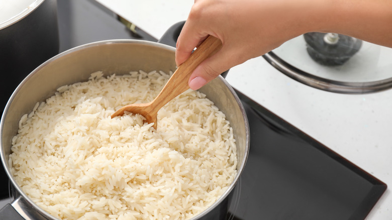 stirring rice with wooden spoon