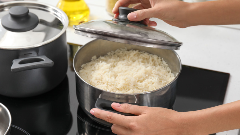 lifting lid off of cooked rice