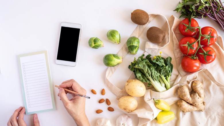 A notepad and a phone next to recipe ingredients 