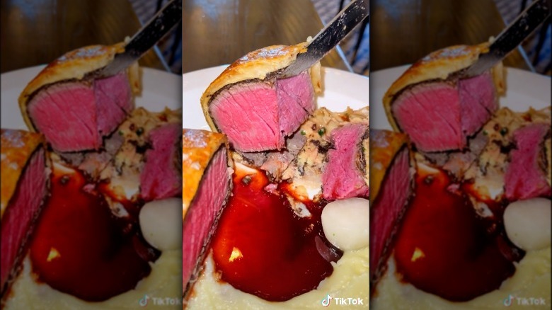 person cutting beef wellington