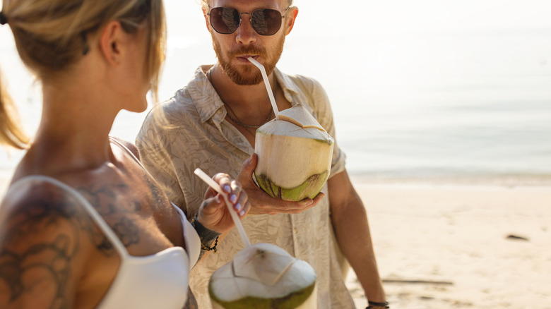 Couple drinking from coconuts