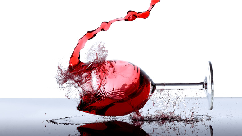 Wine glass falling and shattering on surface