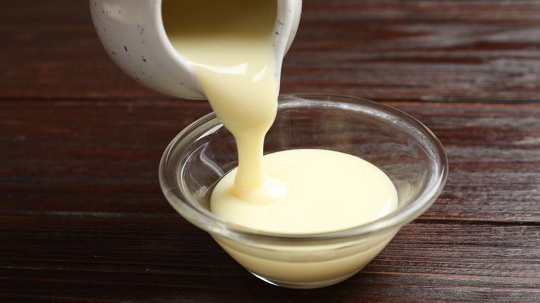 Pouring sweetened condensed milk into bowl