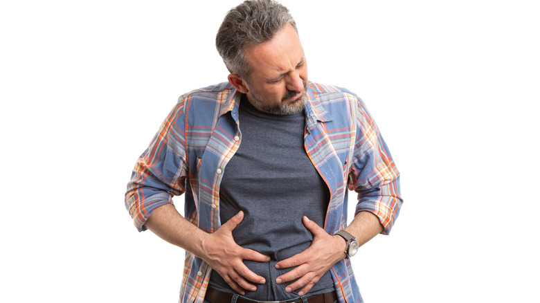 Man in pain holding stomach