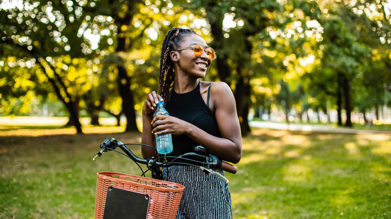 Woman holding water bottle in park