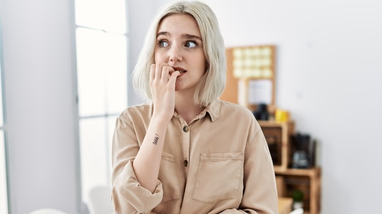 Anxious woman chewing nails