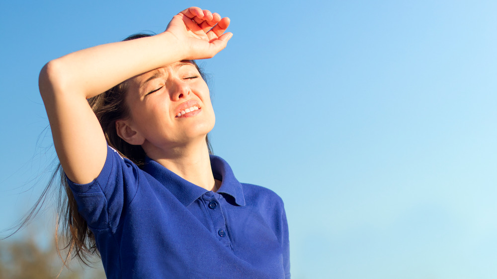 Overheated woman in blue shirt 