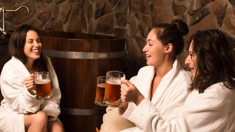 Friends in bathrobes holding beer mugs