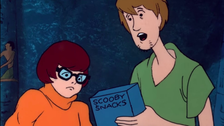 Velma and Shaggy holding Scooby Snacks