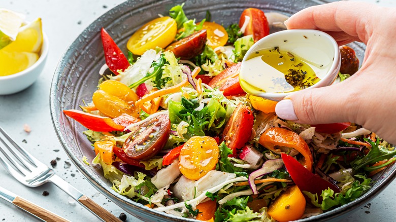 pouring dressing on a salad