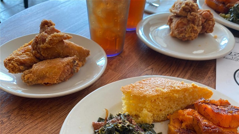 plates of fried chicken, greens, and cornbread