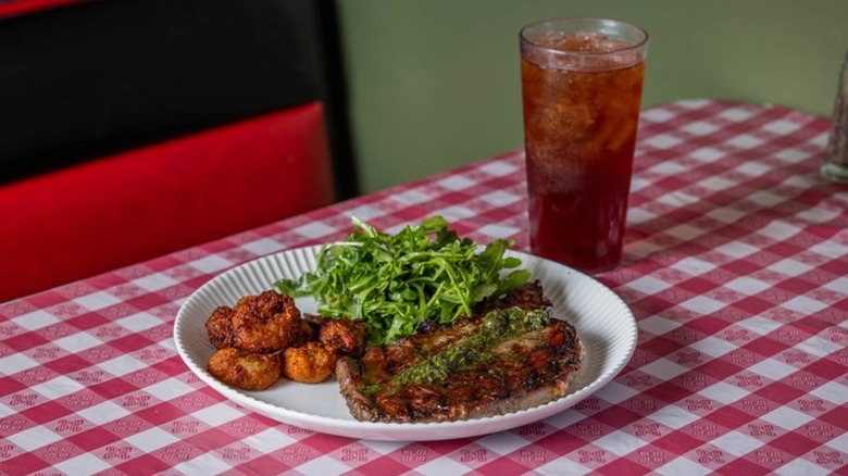 Ribeye steak with salad, salsa verde, and Texas gnocchi