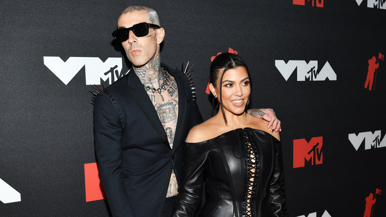 Travis Barker and Kourtney Kardashian in black on red carpet