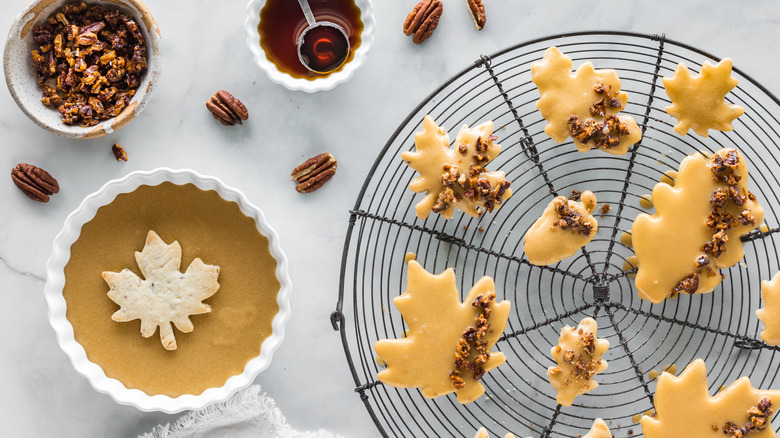 Maple leaf shaped shortbread cookies with a maple glaze and candied pecans