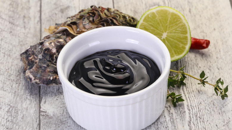 Bowl of oyster sauce with oysters alongside