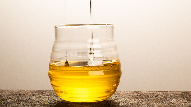 golden syrup with wooden dipper in glass jar