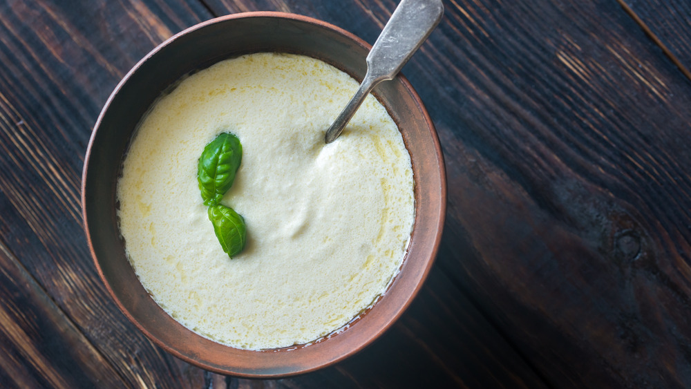 A bowl of Alfredo sauce garnished with basil