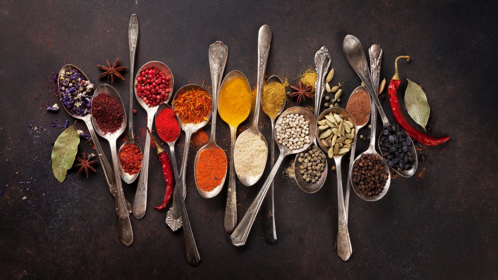 silver spoons filled with a variety of spices and herbs 