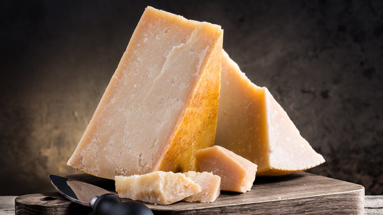 Wedges of Parmesan cheese on a wooden cutting board