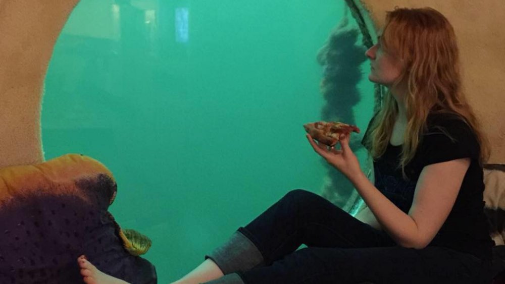 Guest enjoying underwater pizza at Jules' Undersea Lodge