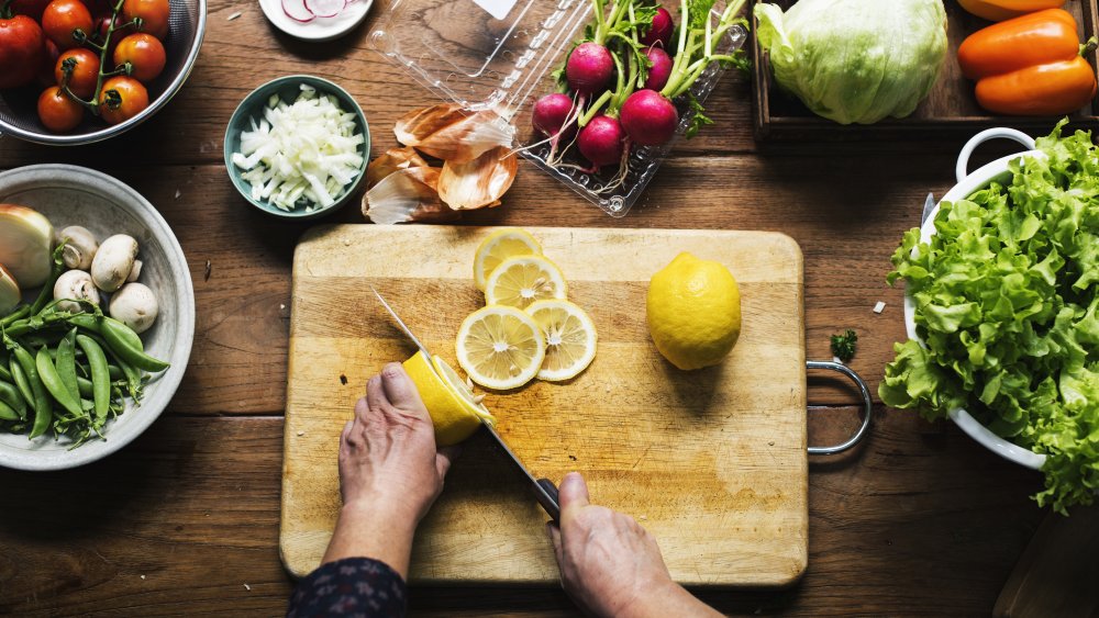 knife cutting lemons on a cutting board