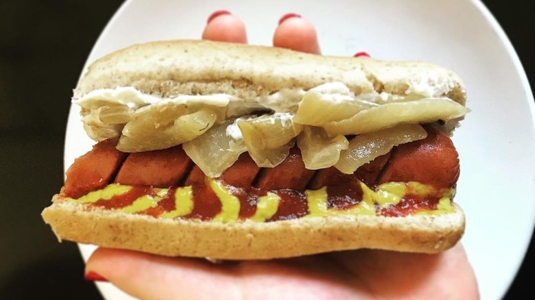 holding Seatte-style hot dog