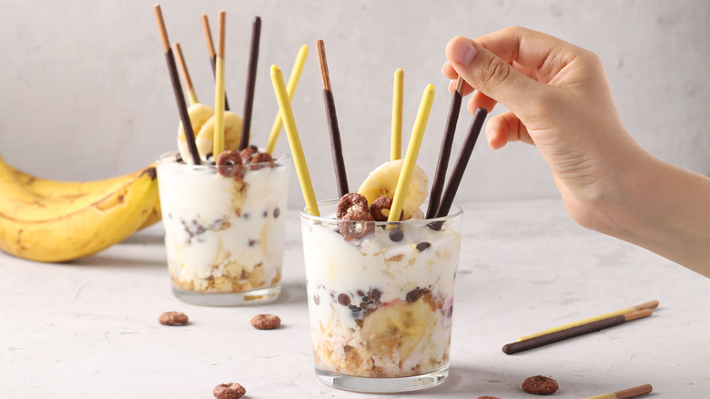 a hand reaching for pocky sticks in dessert