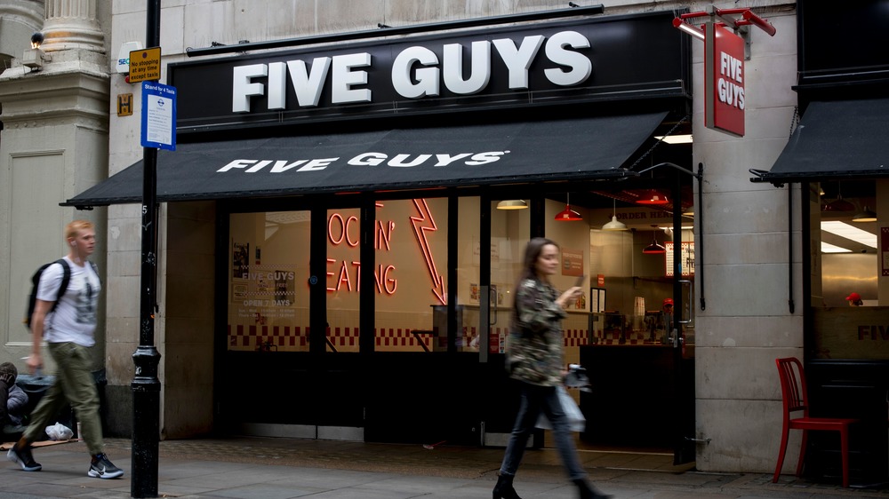 Five Guys storefront, people walking