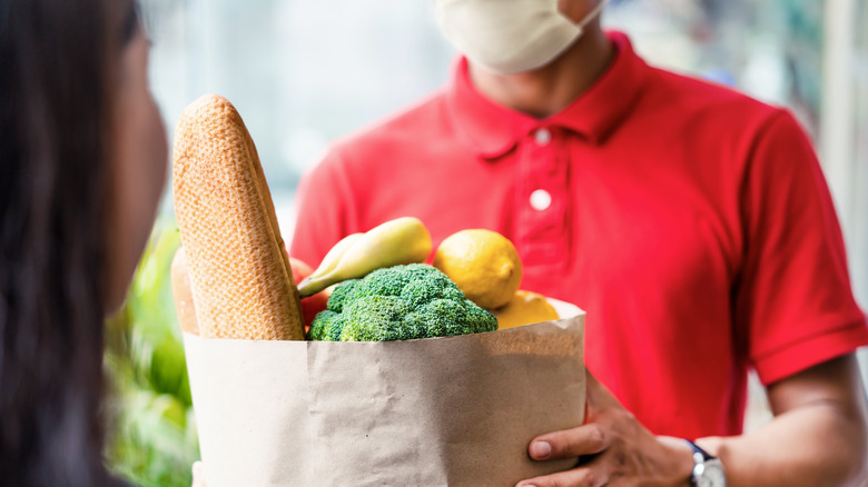 Person in red polo delivering groceries to customer