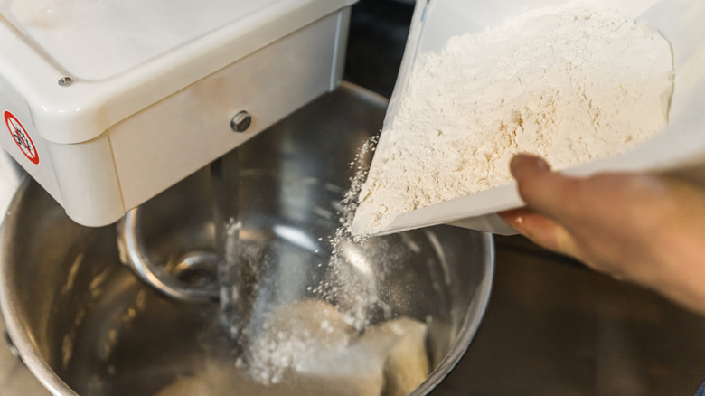 adding flour to a mixer when baking bread