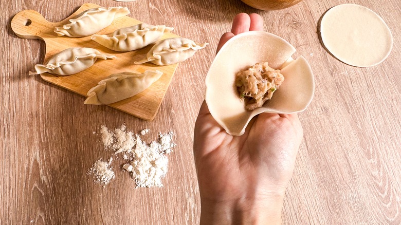 Hands filling dumplings