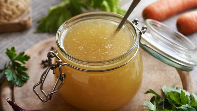 Chicken broth in a jar with a spoon