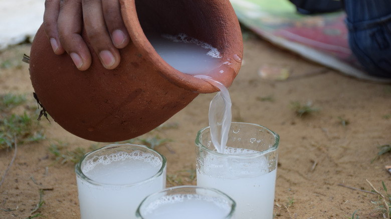 Palm wine in clay pot and glasses 