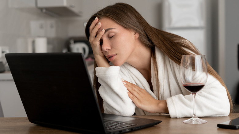 Woman falling asleep in front of laptop