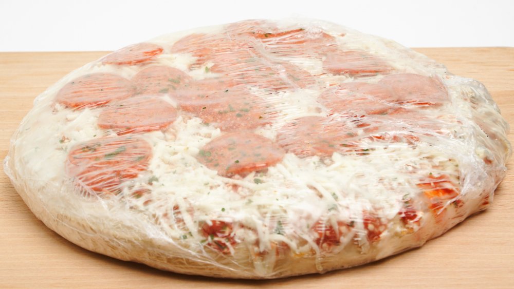 Frozen pepperoni pizza wrapped in plastic