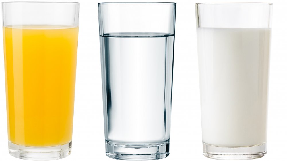 glasses of orange juice, water, and milk