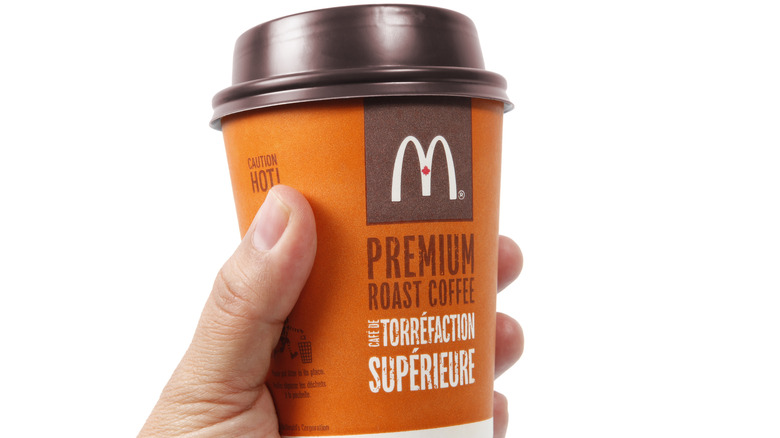 hand holding McDonald's coffee cup